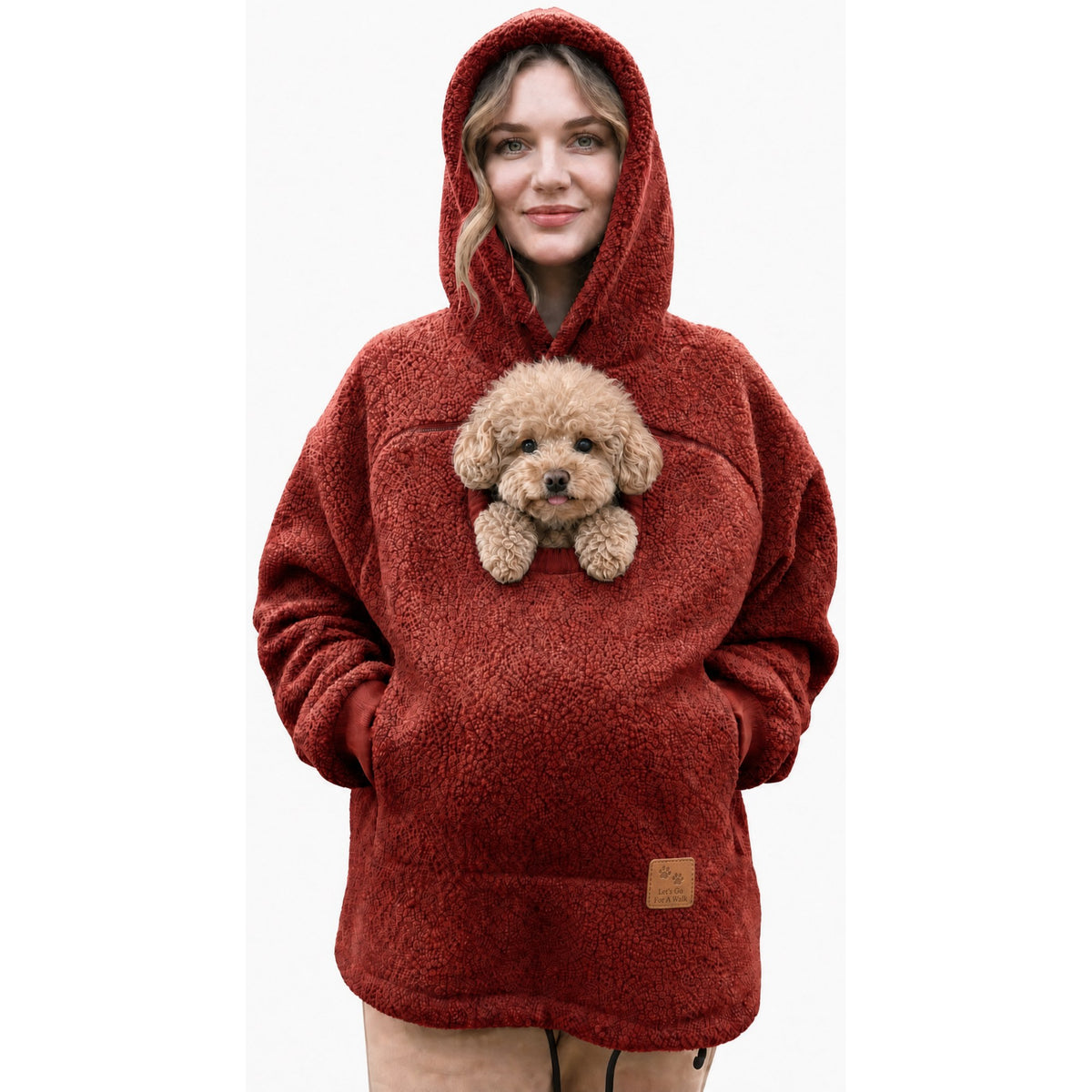 Woman wearing the Cudaroo pet pouch hoodie in red with a small poodle in the chest pouch